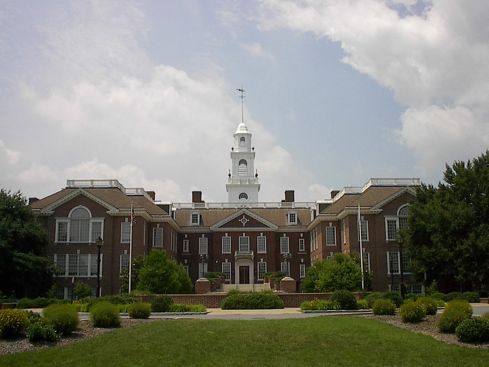 Legislative Hall, the Delaware State Capitol in Dover, a red brick building with a white clock tower under a partly cloudy sky