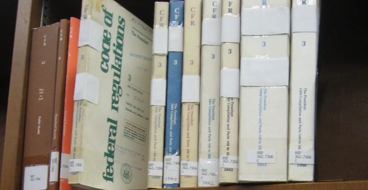 Bound volumes of the Code of Federal Regulations on a library shelf, including a Title 42 Public Health volume