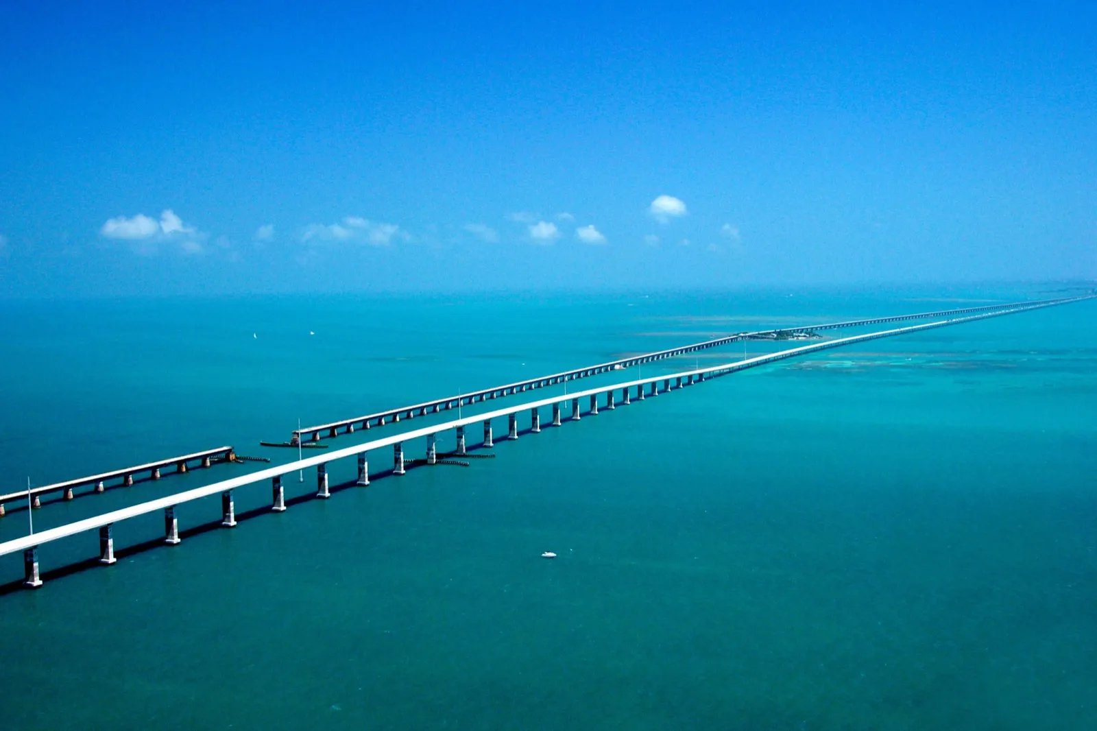 An aerial view of the Seven Mile Bridge in the Florida Keys, running beside the old rail bridge over turquoise water