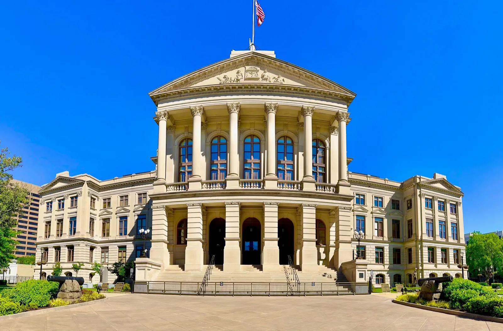 The front of the Georgia State Capitol in Atlanta, with its columned portico and front steps under a clear blue sky