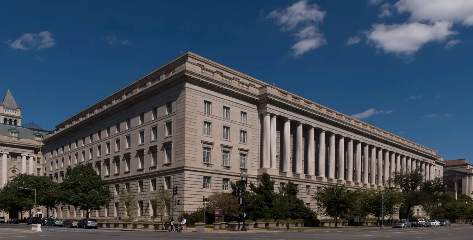 The Internal Revenue Service Building in Washington, D.C., a long stone building with a row of tall columns, under a blue sky