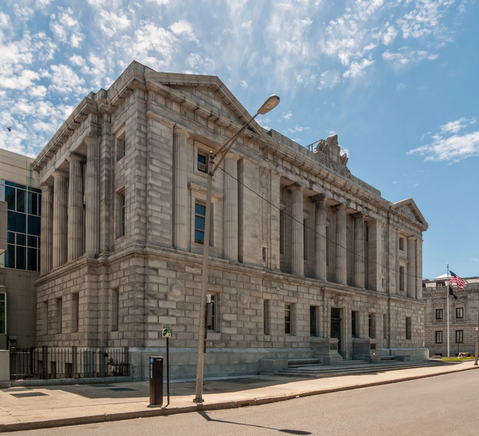 The granite Cumberland County Courthouse in Portland, Maine, with tall columns along its front, under a blue sky