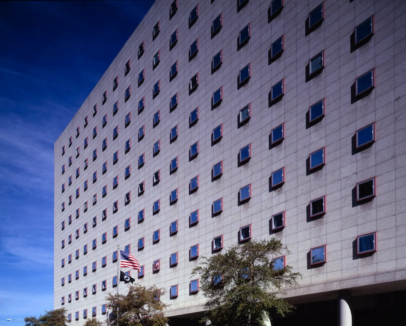 The federal courthouse in Houston, Texas, a pale concrete building with rows of small square windows, under a deep blue sky
