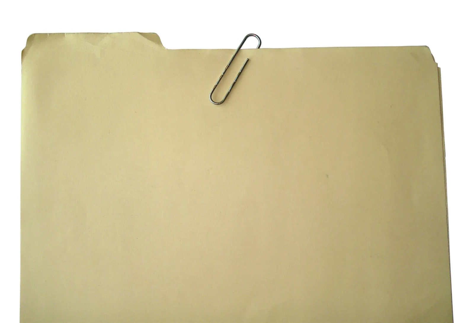 A tan manila file folder with a silver paperclip on its top edge