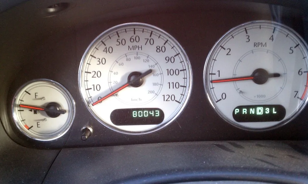 A minivan dashboard with the odometer reading 80,043 miles and the fuel gauge at about half