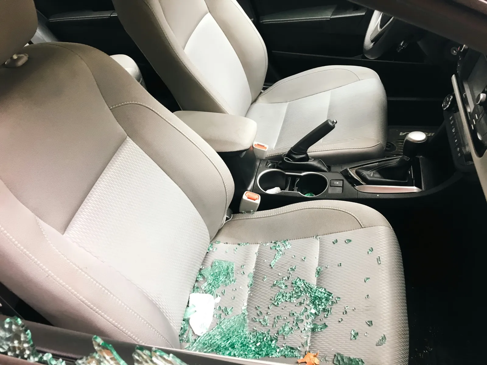 Shattered window glass on the front seat of a car after a break-in