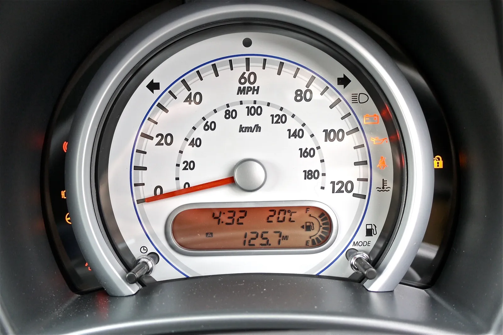 A car speedometer with a digital display showing a trip distance of 125.7 miles