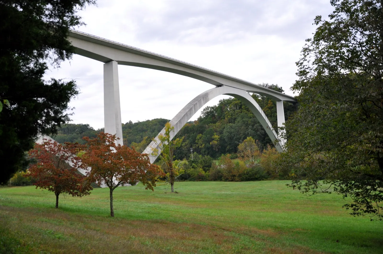 The concrete Double Arch Bridge of the Natchez Trace Parkway spanning a green hollow near Franklin, Tennessee, under a cloudy sky