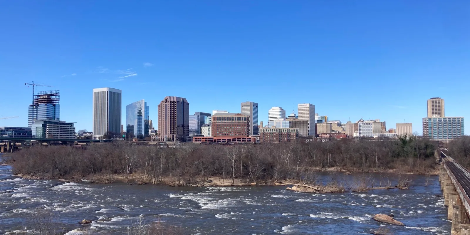 The downtown Richmond skyline on a clear day, seen across the rapids of the James River