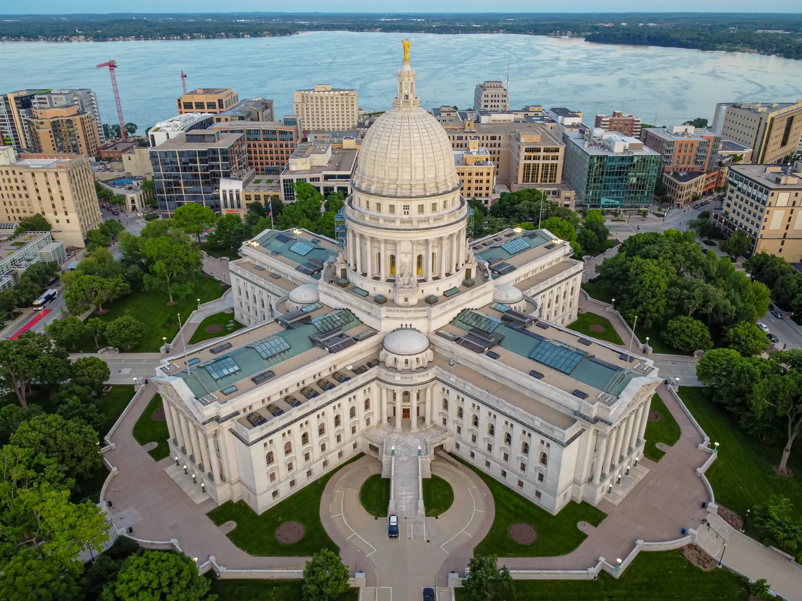 Aerial view of the Wisconsin State Capitol in Madison, with downtown buildings and a lake behind it